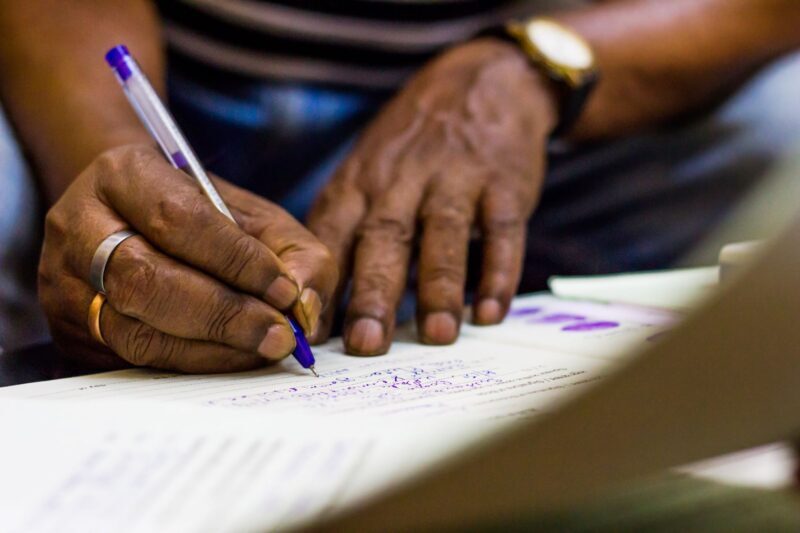 Closeup of someone writing a handwritten (or holographic) will.