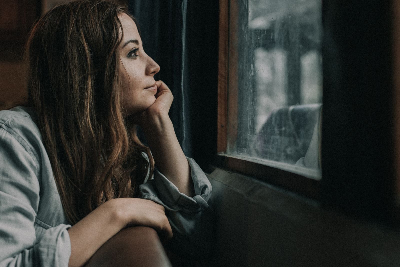 woman standing alone window